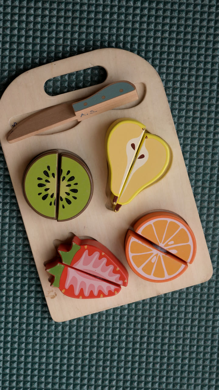 Frutas de madera y una tabla de juego del consultorio